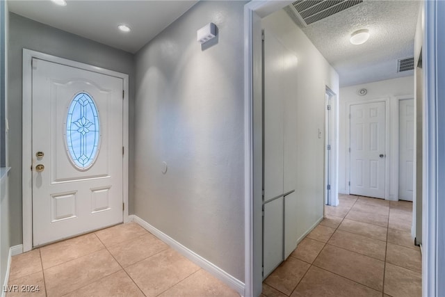 tiled entryway featuring a textured ceiling