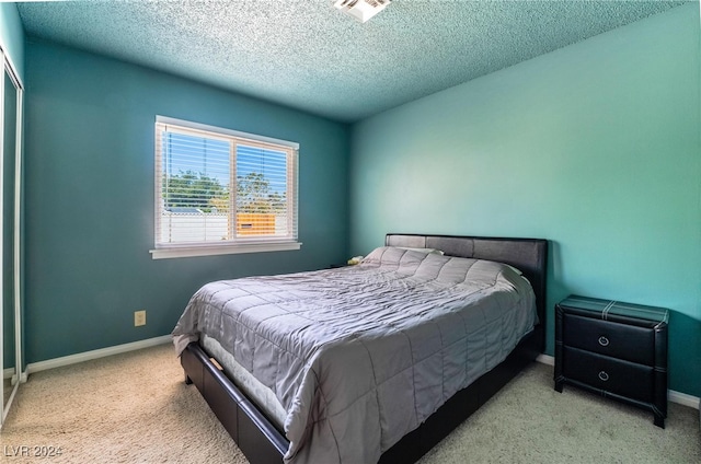 bedroom with light carpet and a textured ceiling