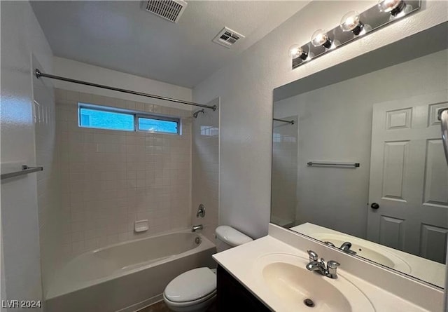 full bathroom featuring vanity, tiled shower / bath combo, and toilet