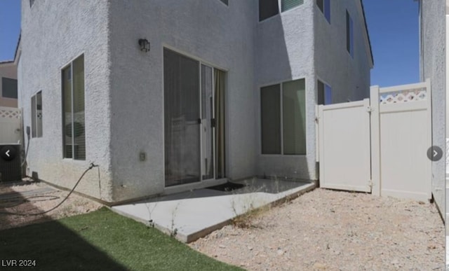 view of side of home with central AC unit and a patio area