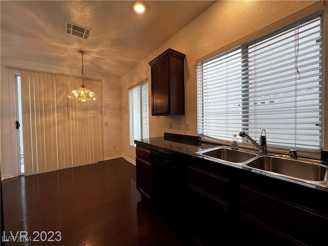 kitchen featuring pendant lighting, sink, black dishwasher, dark hardwood / wood-style flooring, and a chandelier