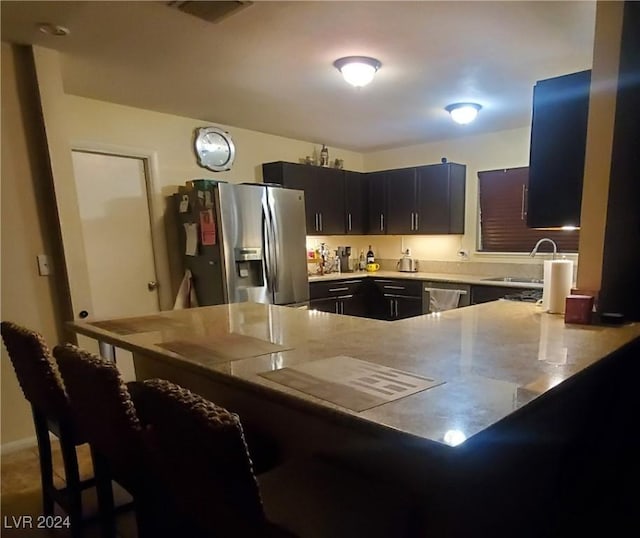 kitchen with stainless steel appliances, kitchen peninsula, and sink