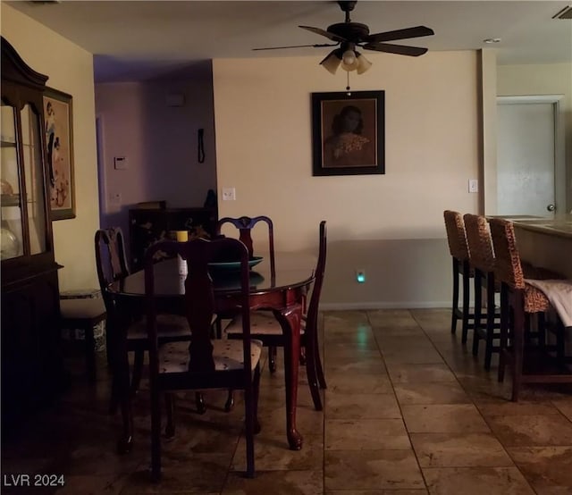 tiled dining space featuring ceiling fan