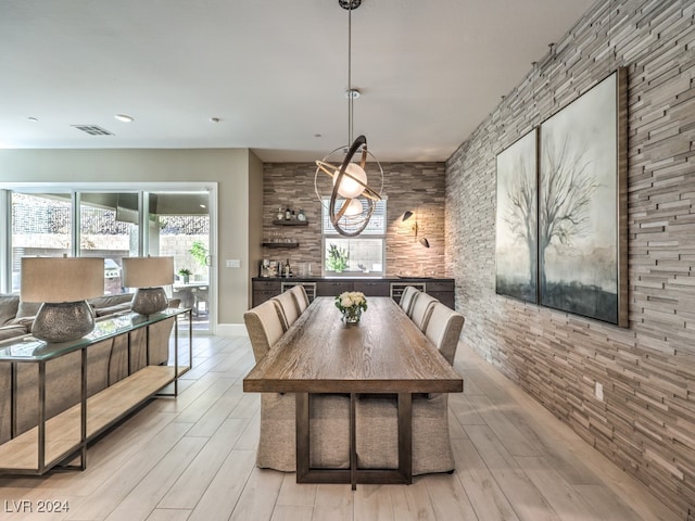 dining space with a notable chandelier and light hardwood / wood-style flooring