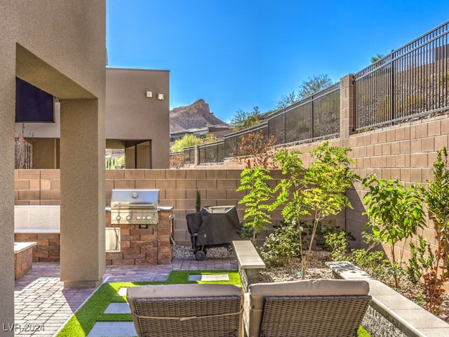 view of patio with area for grilling and a mountain view