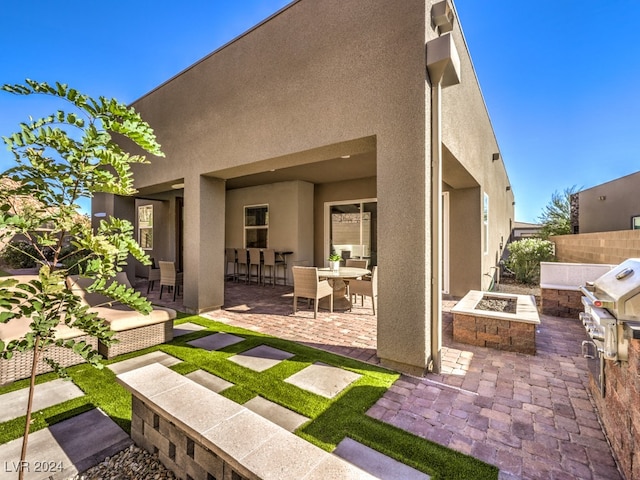 rear view of house featuring a fire pit and a patio