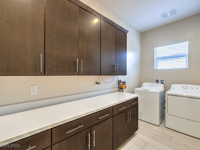 clothes washing area with cabinets and separate washer and dryer