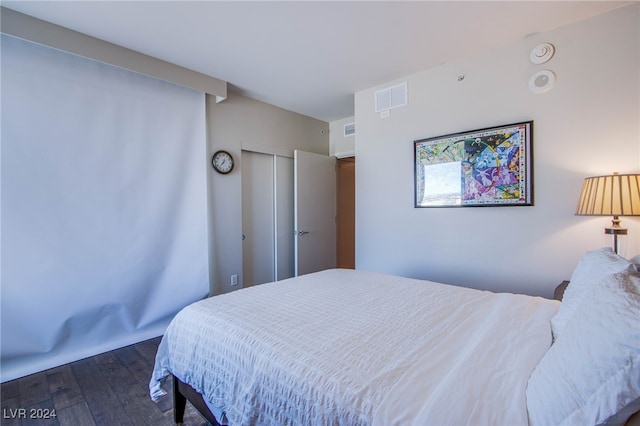 bedroom with a closet and dark hardwood / wood-style floors