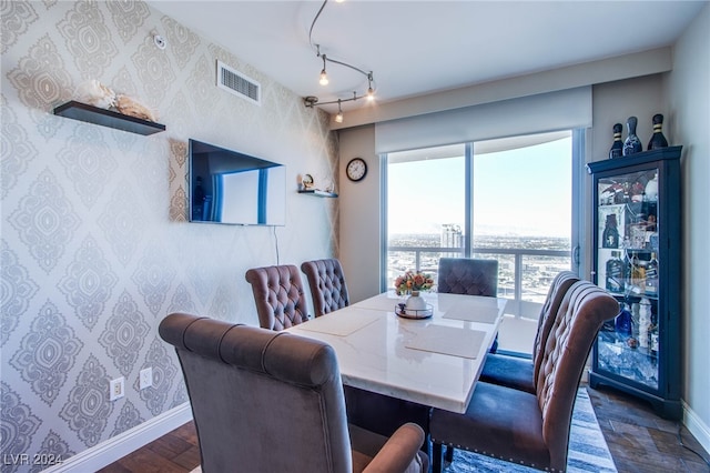 dining space with rail lighting and dark hardwood / wood-style flooring