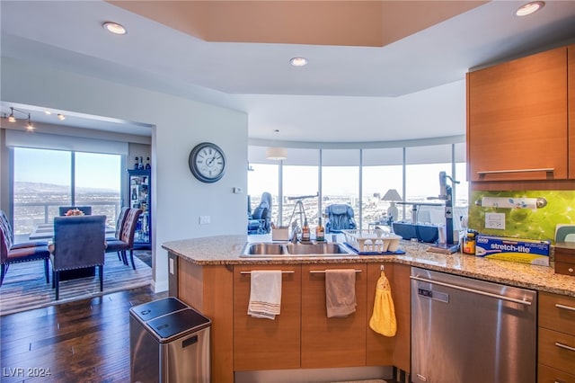 kitchen with stainless steel dishwasher, sink, dark wood-type flooring, and light stone countertops