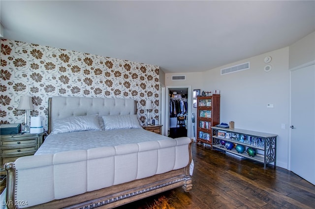 bedroom featuring a spacious closet, dark wood-type flooring, and a closet