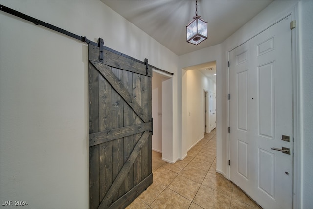 foyer entrance with a barn door and light tile patterned floors