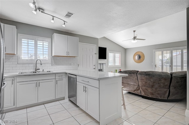 kitchen featuring a healthy amount of sunlight, sink, kitchen peninsula, and white cabinets