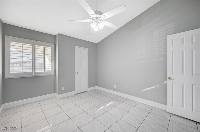 unfurnished room featuring lofted ceiling, light tile patterned flooring, and ceiling fan