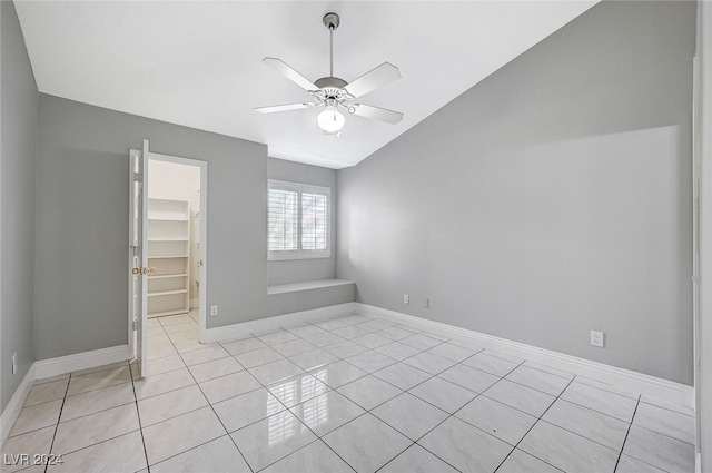 tiled empty room featuring lofted ceiling and ceiling fan