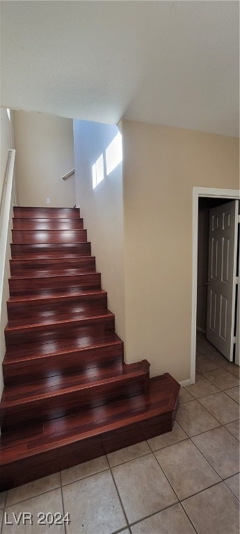 staircase featuring tile patterned flooring