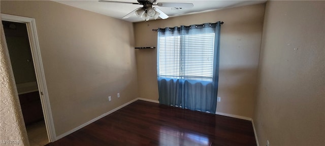 empty room with ceiling fan and dark hardwood / wood-style flooring