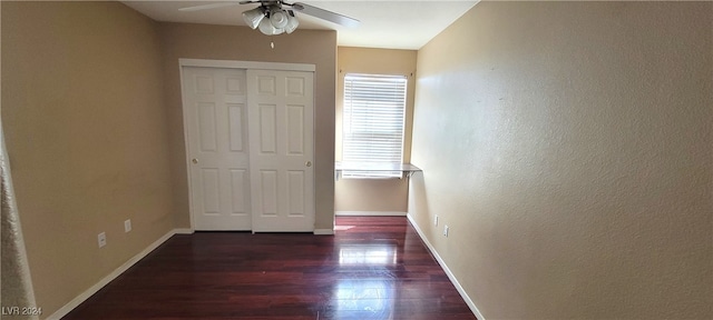 unfurnished bedroom with a closet, dark wood-type flooring, and ceiling fan