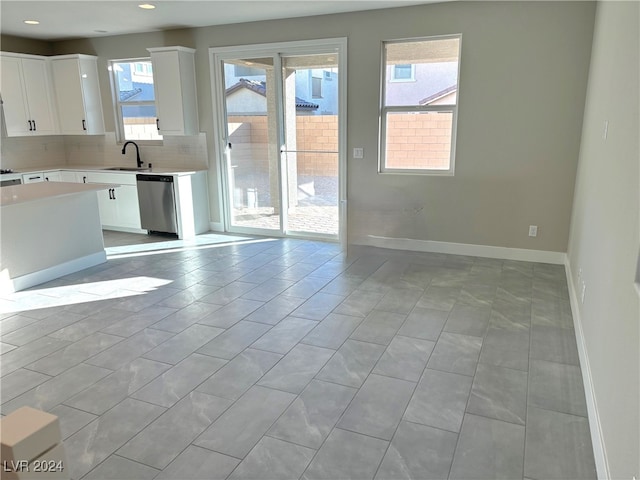 kitchen featuring dishwasher, white cabinetry, sink, and a wealth of natural light