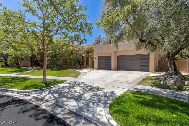 southwest-style home featuring a front yard and a garage