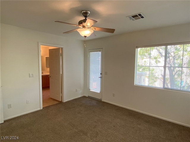 carpeted spare room with ceiling fan