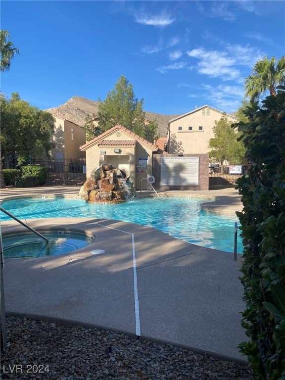 view of swimming pool featuring a patio, a mountain view, and a hot tub