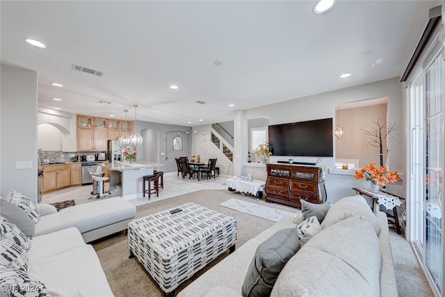 living room featuring a chandelier and sink