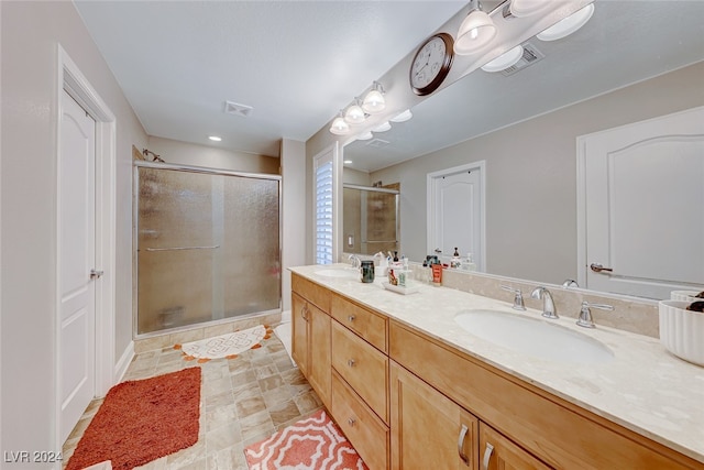 bathroom featuring vanity and a shower with door