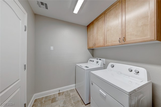 washroom with cabinets and washing machine and dryer