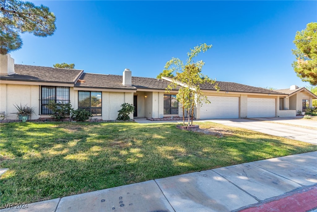 ranch-style home featuring a front yard and a garage