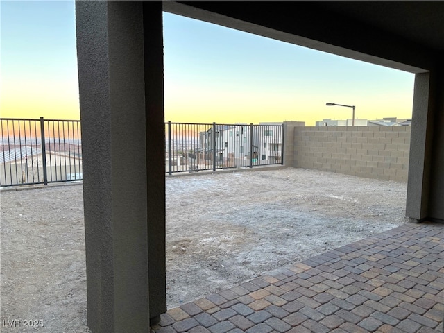 patio terrace at dusk featuring a water view