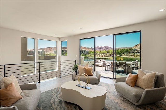 living room with a mountain view, plenty of natural light, and light wood-type flooring