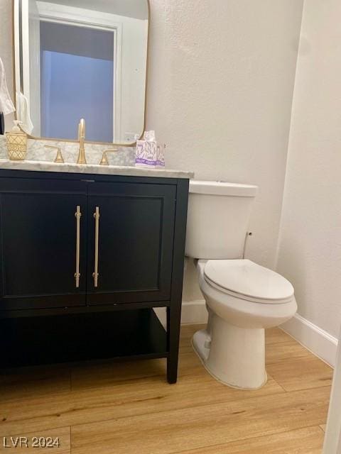 bathroom with vanity, wood-type flooring, and toilet