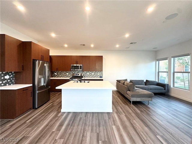 9847 Kings Glen St, Las Vegas, NV 89141 - kitchen featuring stainless steel appliances, light countertops, a sink, wood finished floors, and open floor plan