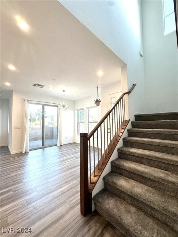 9847 Kings Glen St, Las Vegas, NV 89141 - stairway with wood finished floors, a chandelier, baseboards, and recessed lighting