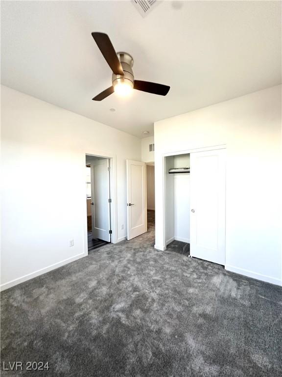 9847 Kings Glen St, Las Vegas, NV 89141 - unfurnished bedroom featuring dark carpet, baseboards, a closet, and a ceiling fan