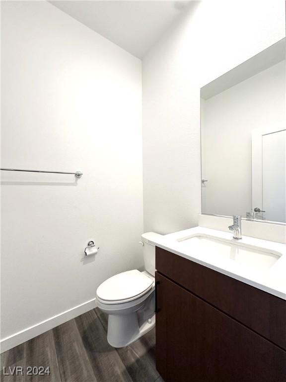 9847 Kings Glen St, Las Vegas, NV 89141 - bathroom featuring wood finished floors, toilet, vanity, and baseboards