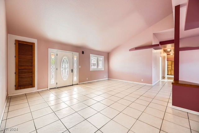 foyer entrance with light tile patterned floors and lofted ceiling