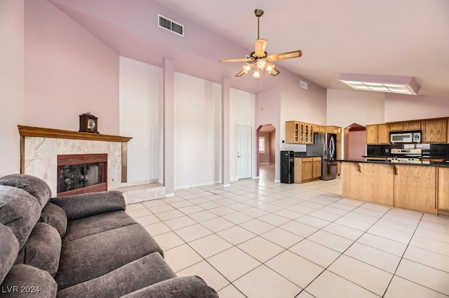 tiled living room with a high end fireplace, high vaulted ceiling, and ceiling fan