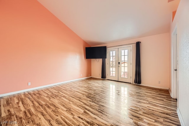 unfurnished room featuring french doors, lofted ceiling, and wood-type flooring