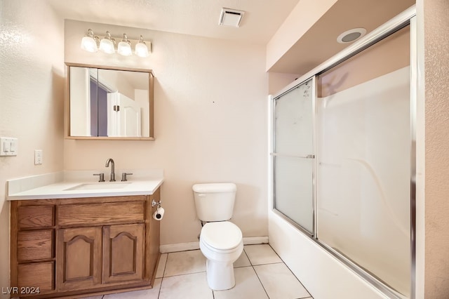 full bathroom with tile patterned flooring, vanity, toilet, and shower / bath combination with glass door