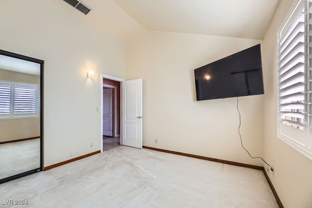 unfurnished bedroom featuring vaulted ceiling and multiple windows