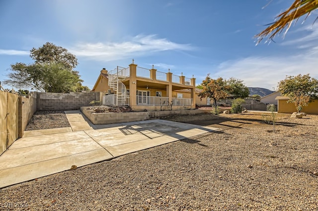 rear view of property with a balcony and a patio