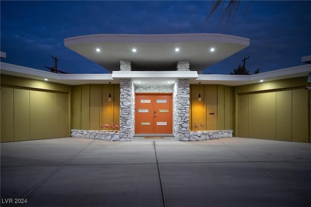 patio at night featuring a garage