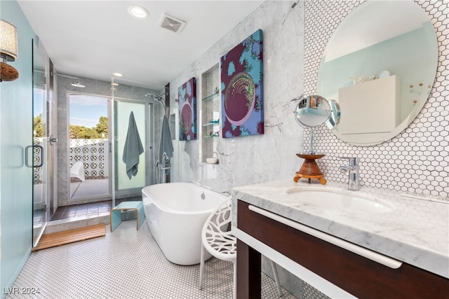 bathroom featuring vanity, tile patterned flooring, tile walls, and a washtub