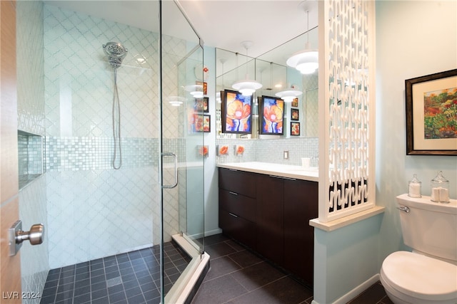 bathroom featuring toilet, a shower with door, tasteful backsplash, tile patterned flooring, and vanity