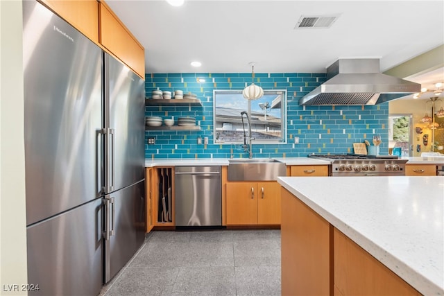 kitchen featuring backsplash, sink, high end appliances, light stone countertops, and island range hood