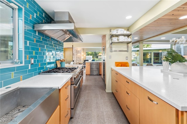 kitchen with range hood, pendant lighting, backsplash, and high end range