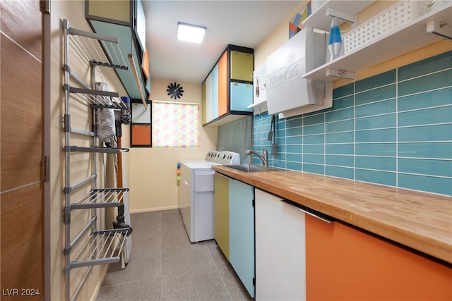 kitchen with washer and dryer, butcher block countertops, and sink