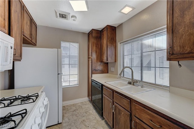 kitchen with white appliances, sink, and a wealth of natural light